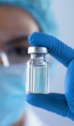 technician in laboratory holding vial